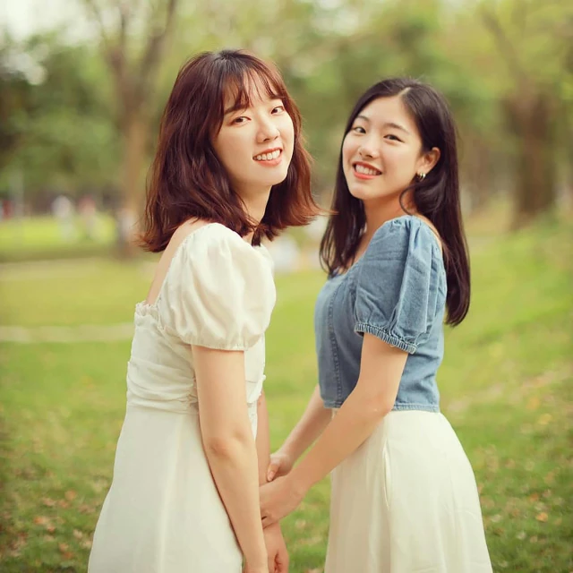 two women are walking side by side holding hands