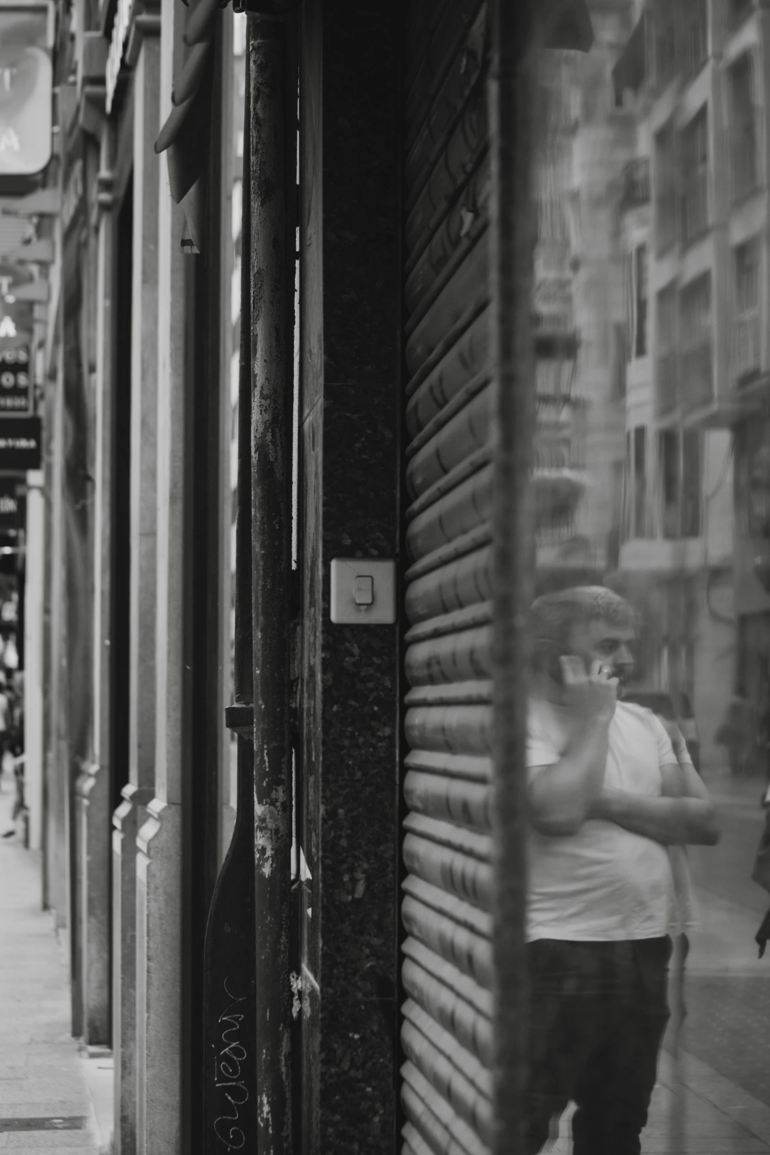 a man is walking and looking at his reflection in a shop window