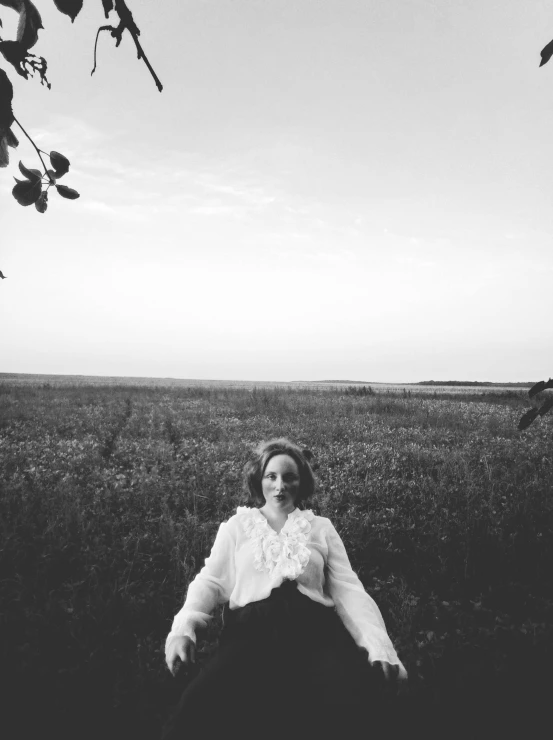 a woman is wearing a white shirt in a field