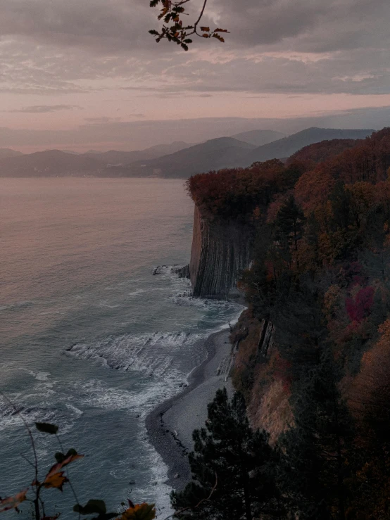 the view from the cliff shows the ocean and mountains