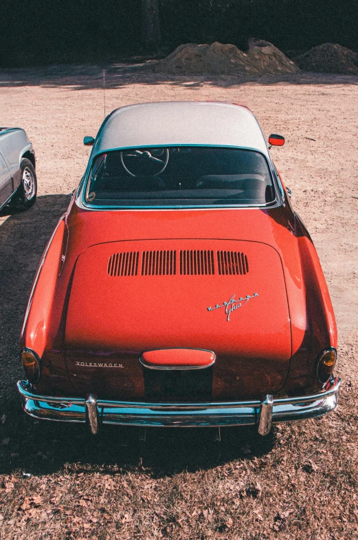 an orange car and a white car sitting together