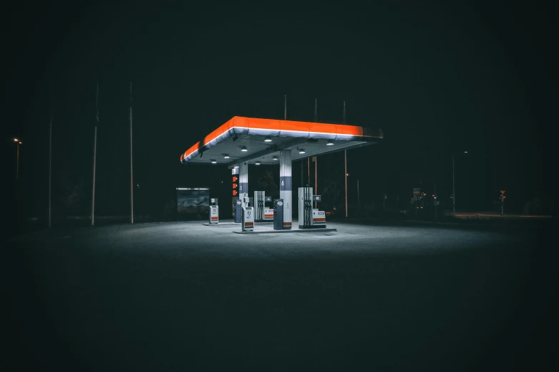 an empty gas station with the light on at night