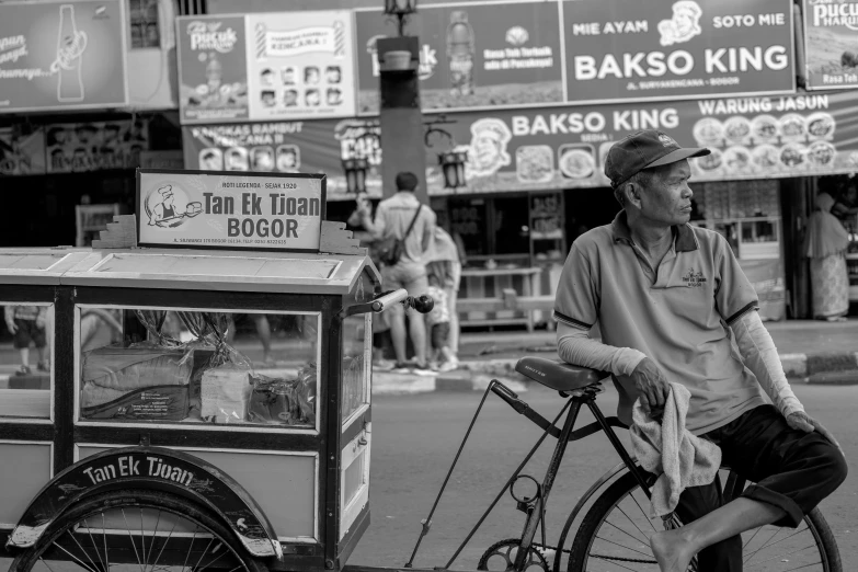 the man is riding his bike next to a food cart