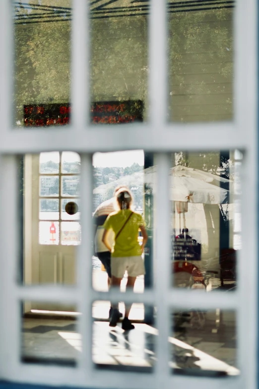 a reflection of a man in a window