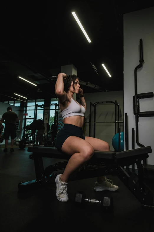 woman squatting on bench in gym area