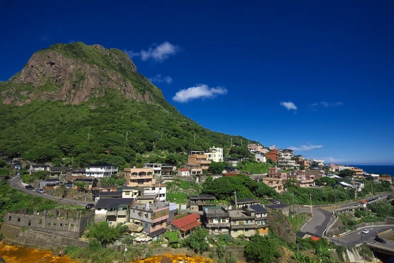 a town with some mountains above it near a body of water