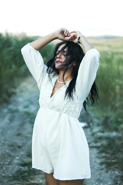 a beautiful woman holding her hair in the air