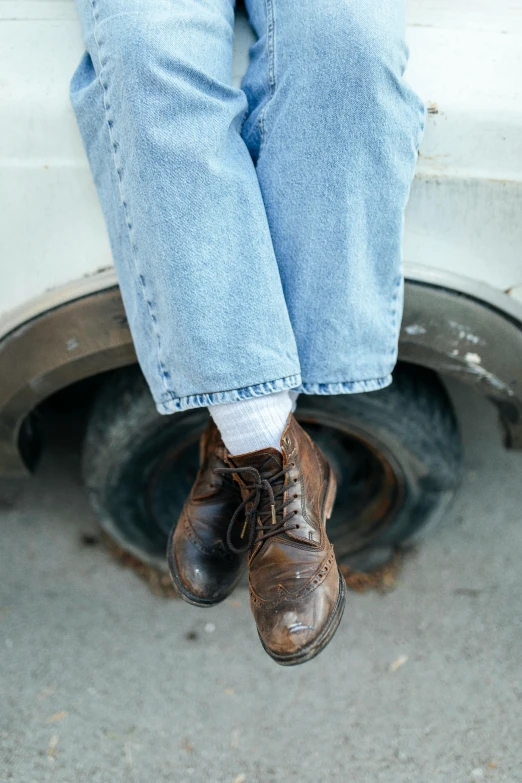 a man sitting on the hood of a white vehicle