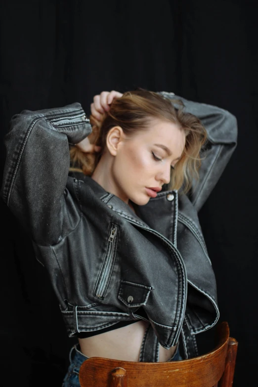 a beautiful young lady leaning up against a wooden chair