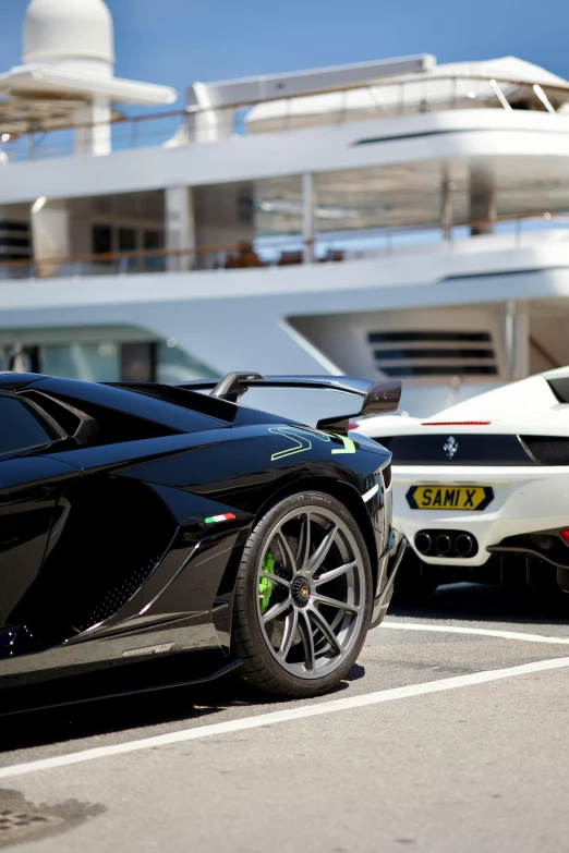 some very nice looking sports cars by a large ship