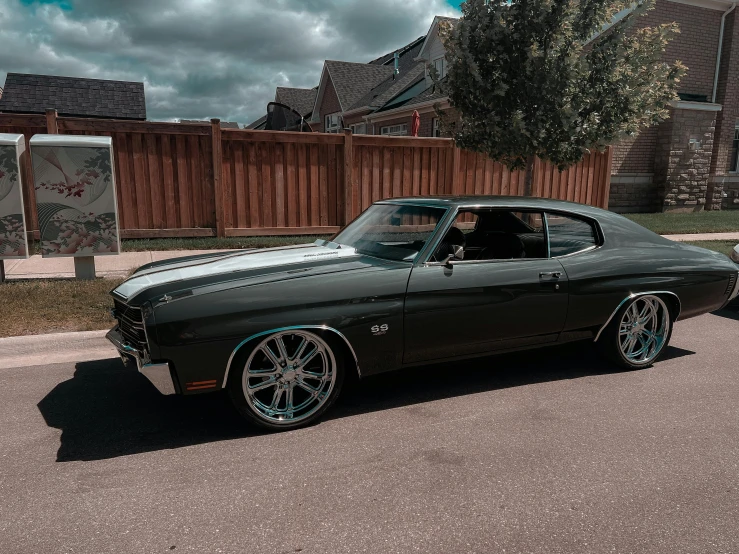 the green chevrolet ss 340 coupe parked on the street