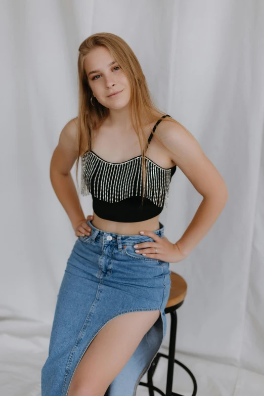 young woman wearing a black crop top and jeans posing for a picture