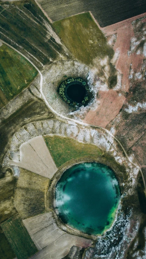 a circular shaped po of green water near a large land