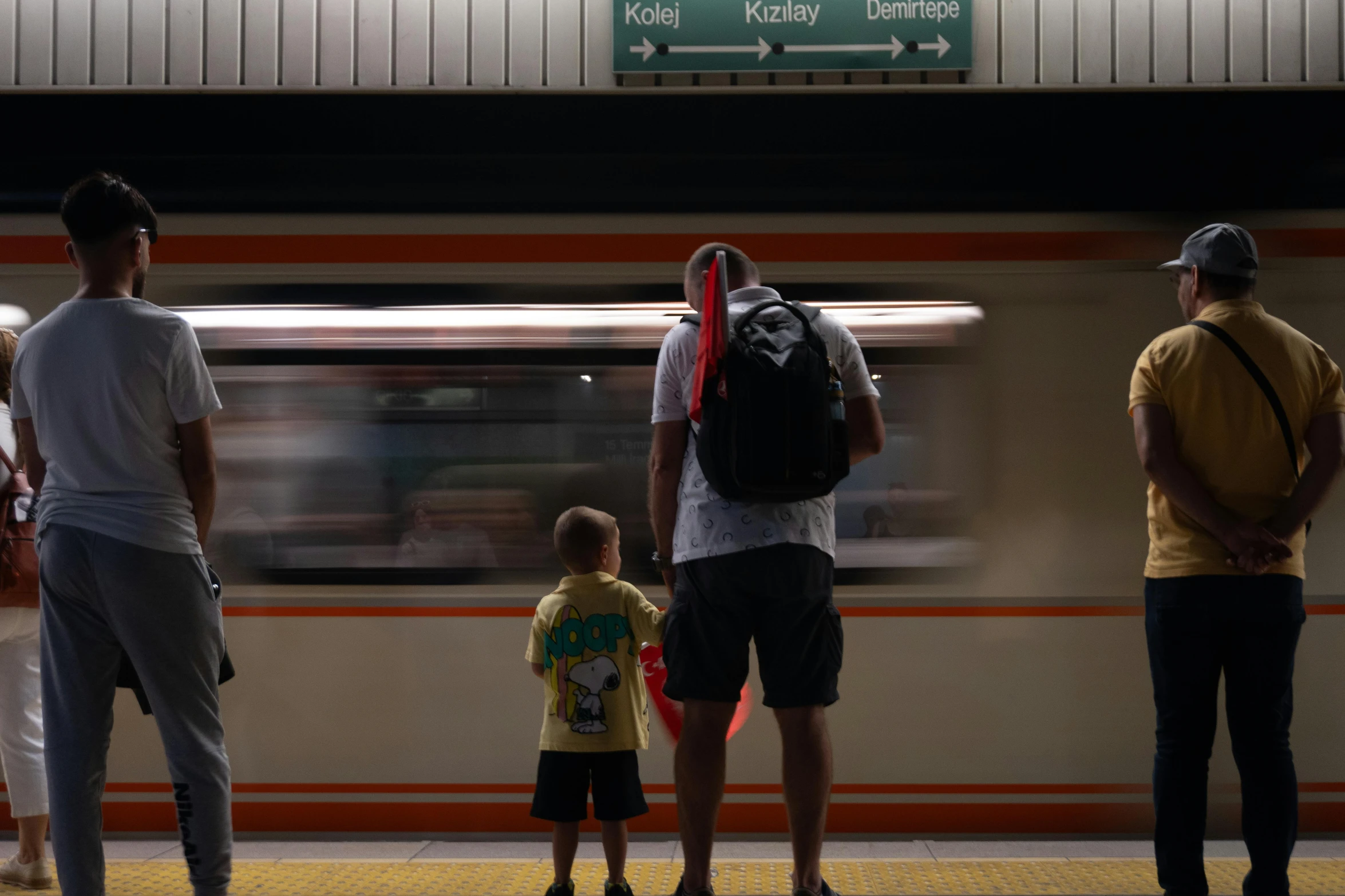 two people wait for the subway train at the station