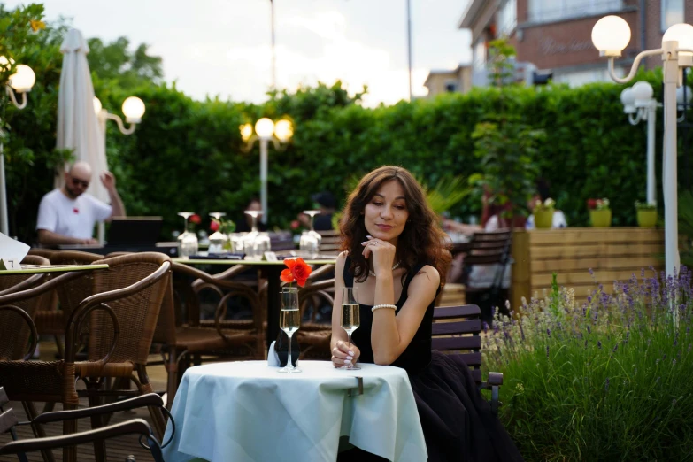 the lady is sitting down with a bottle of wine