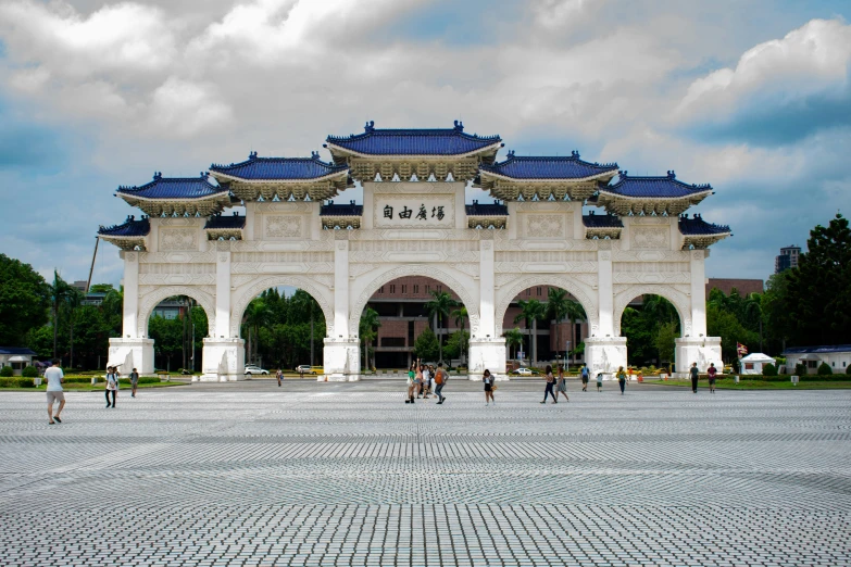 several people standing outside of a building with many pillars