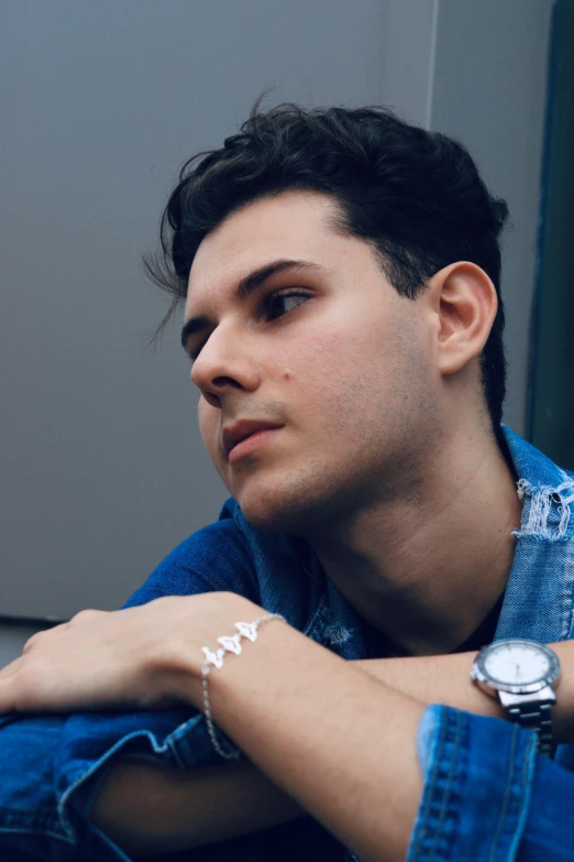 a man wearing a denim jacket and looking off into the distance