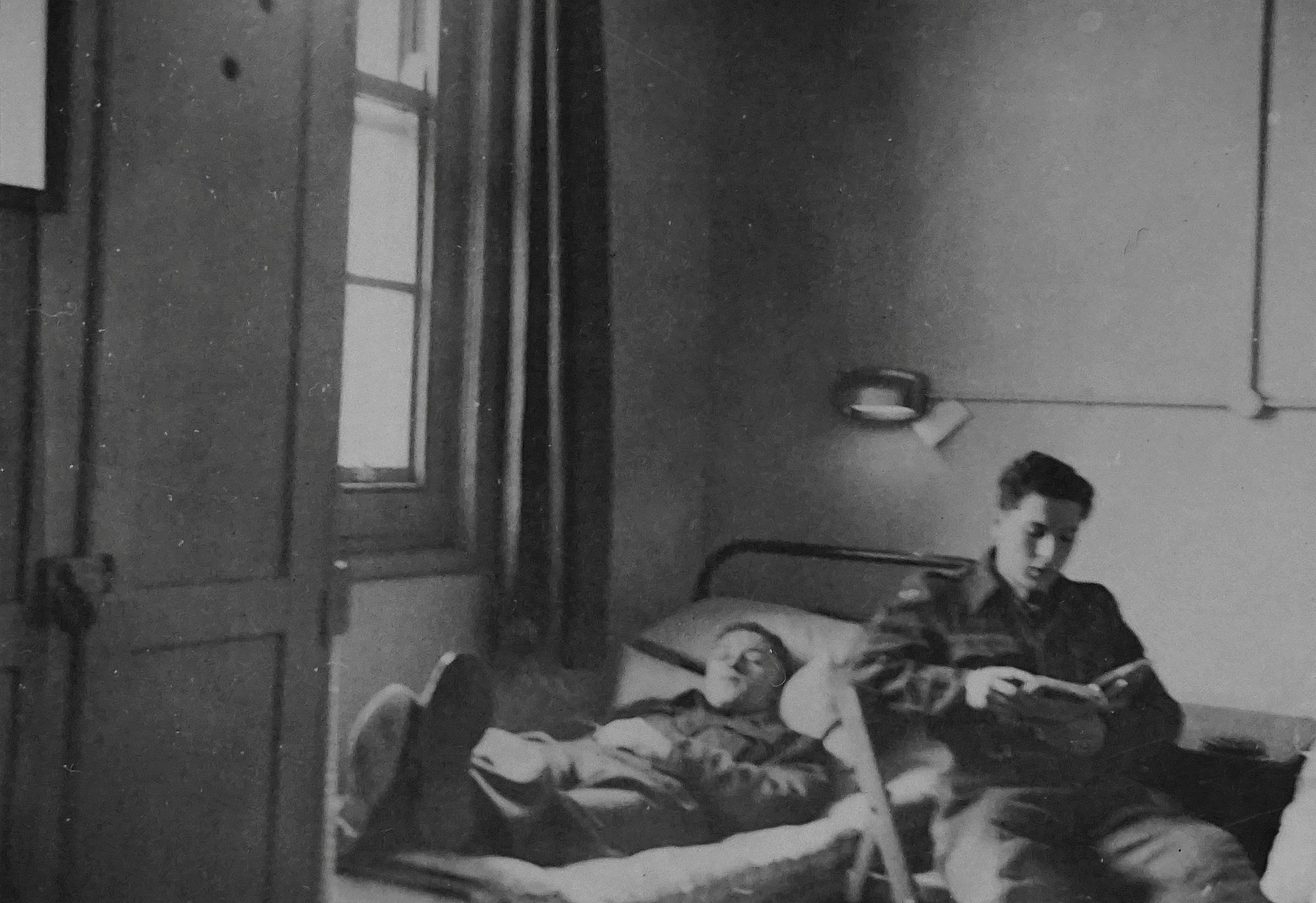 there is a black and white po of two men sitting on a bed