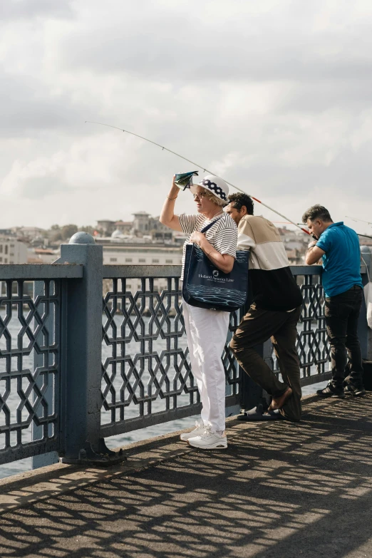 some people looking over a railing and some are fishing