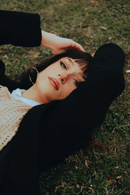 a woman is laying in the grass while looking at the camera