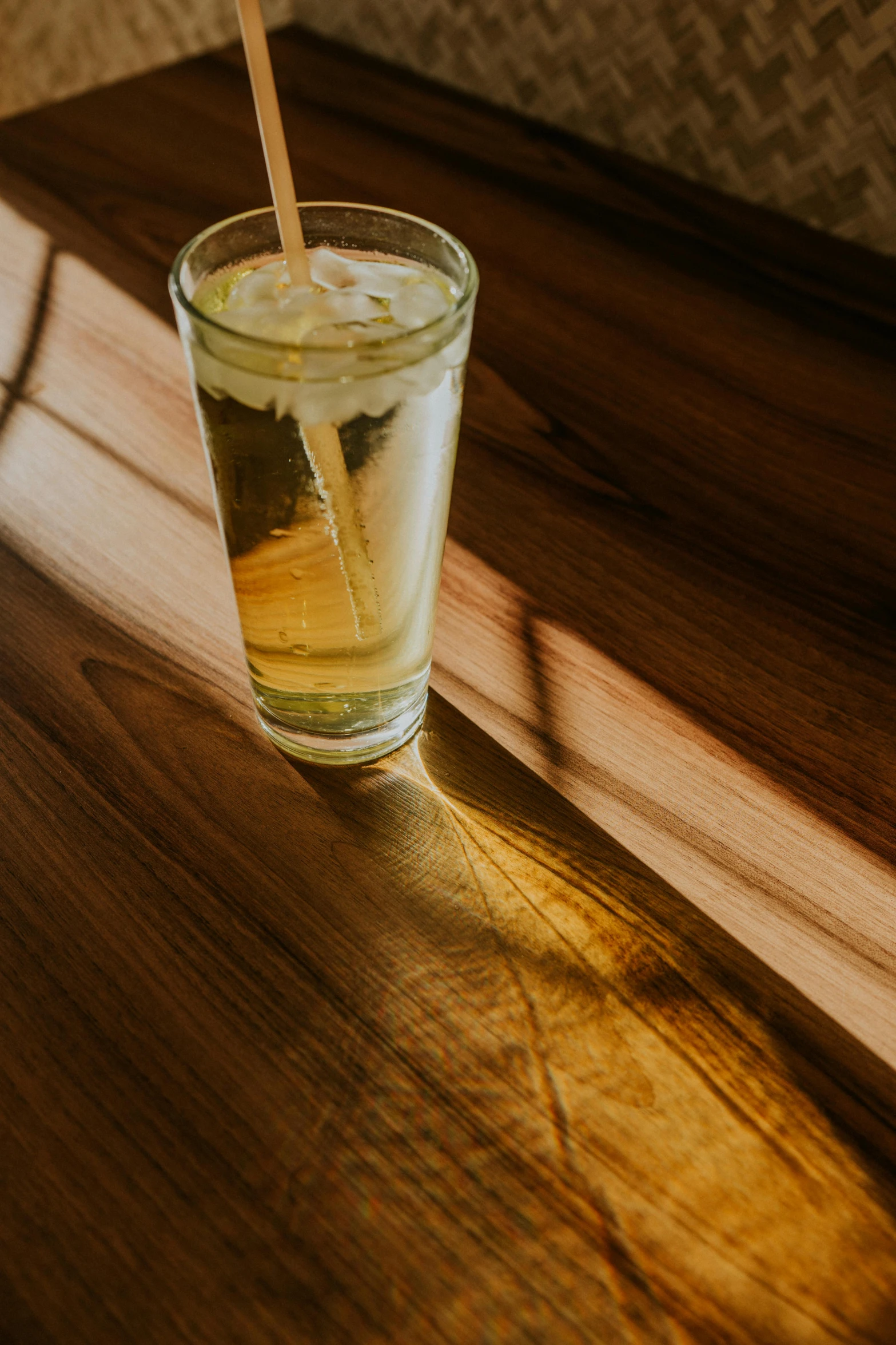 a drink on a wooden table with a straw in the glass