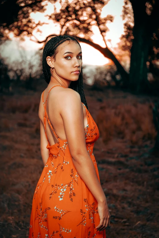 a young woman is standing in a field