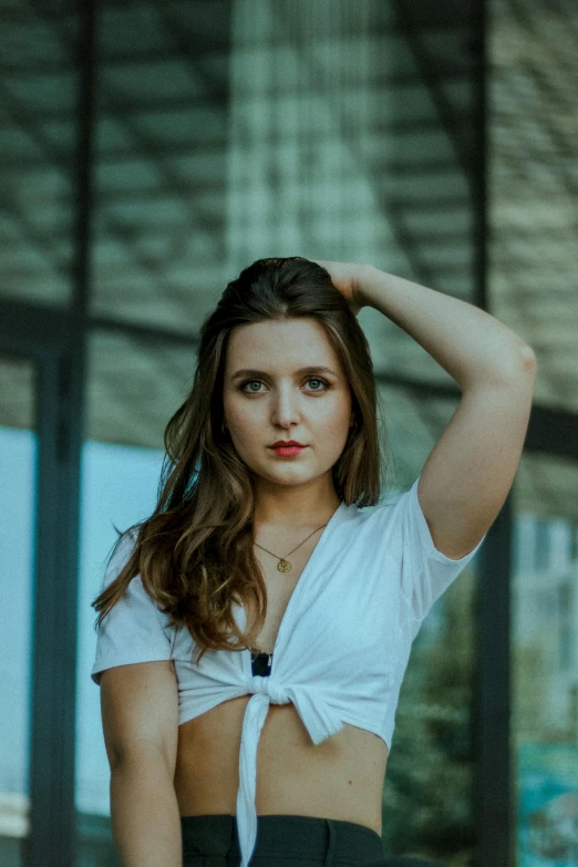 an attractive young woman standing next to a building