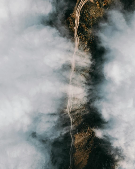 a tree in the middle of a sky filled with clouds