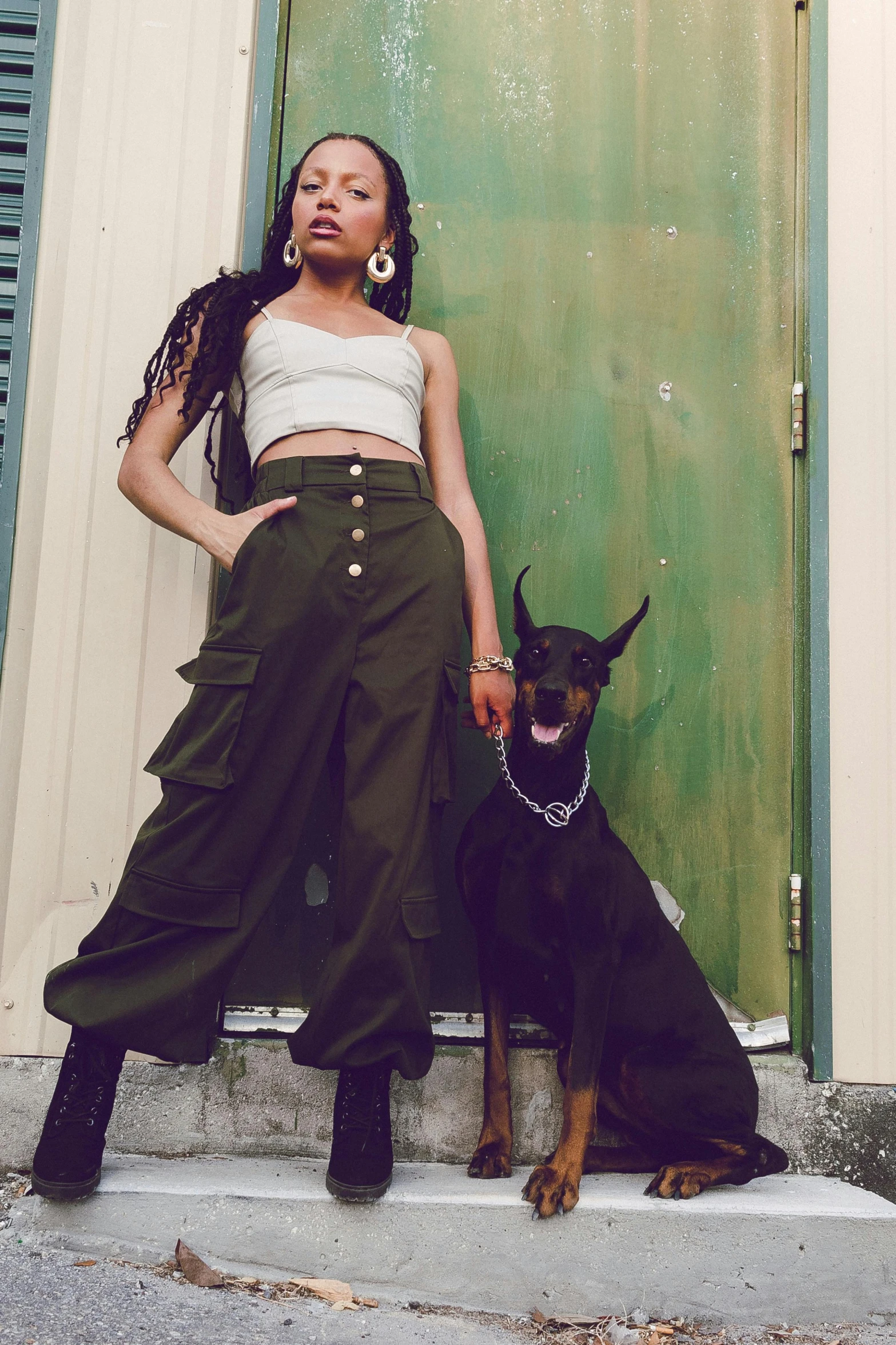 a young lady in a crop top is holding the hand of a dog