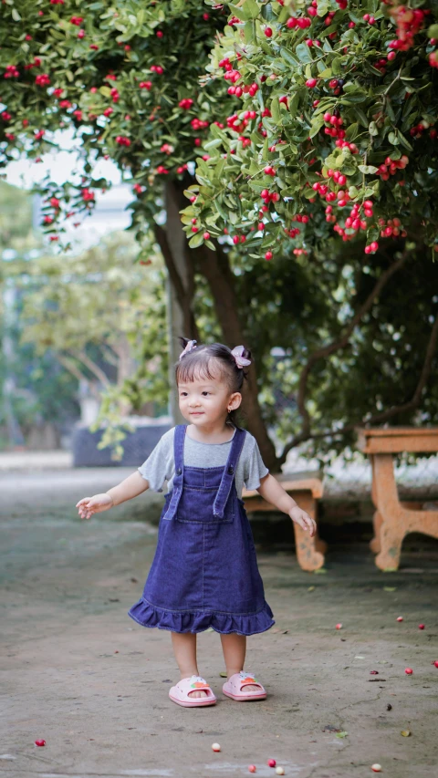 a small girl in blue dress walking away from the picnic table