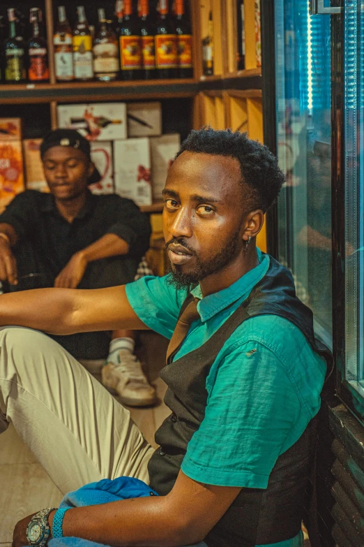 two people sitting on the floor near a store window