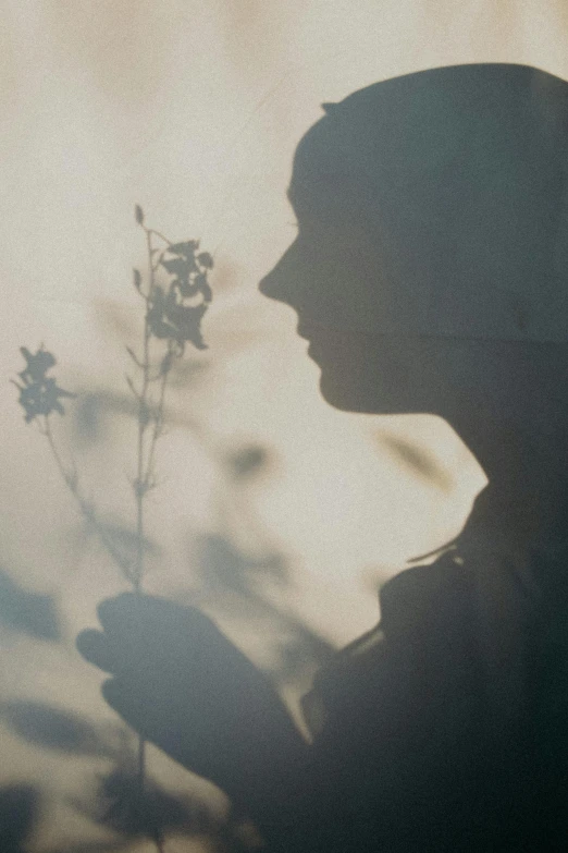 the silhouette of a woman with a flower in her hand