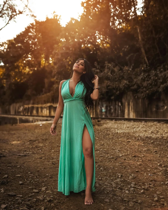 woman posing in green dress by a forest