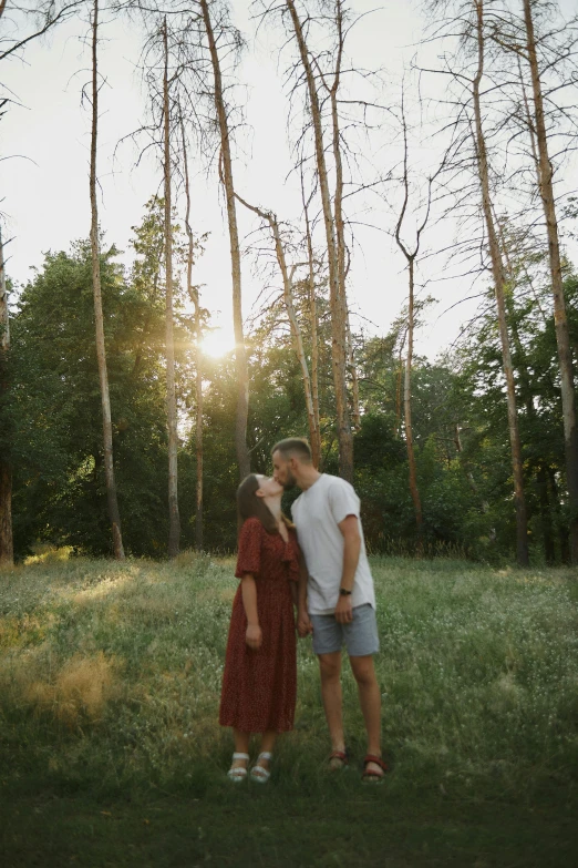 two people standing in the middle of trees