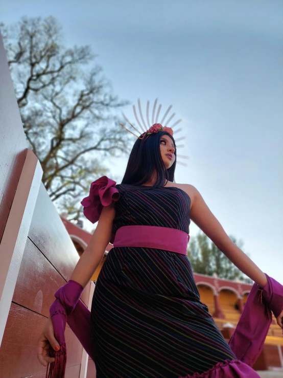 a beautiful woman standing against the side of a building