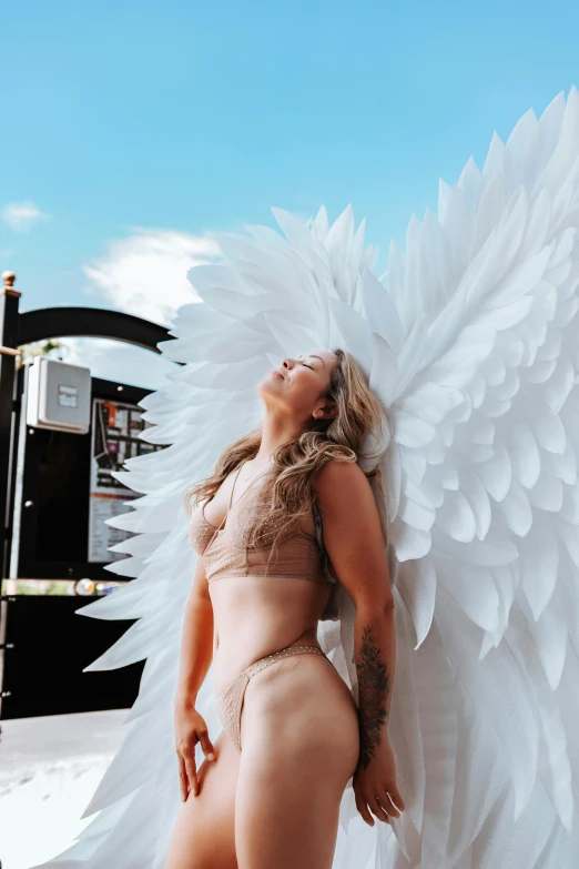 the woman is wearing white angel wings on her 