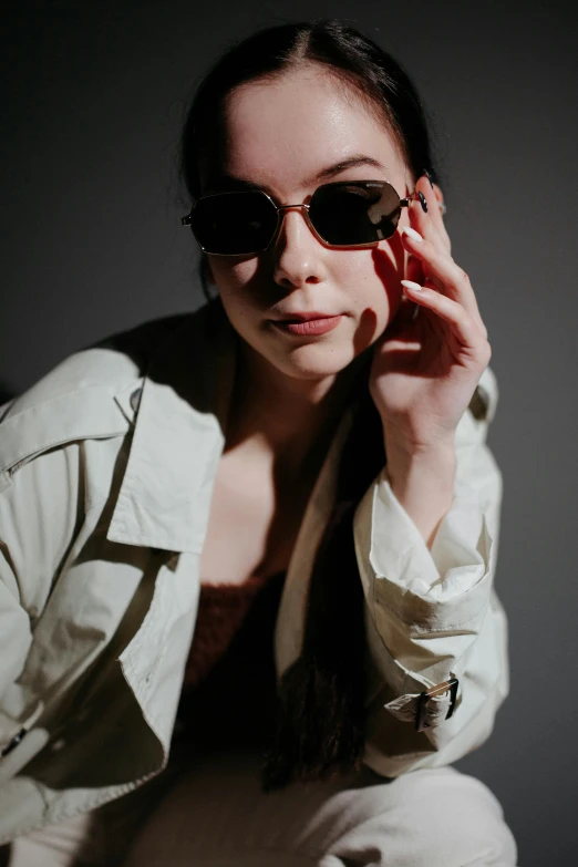 a woman in a white shirt, sunglasses and jacket