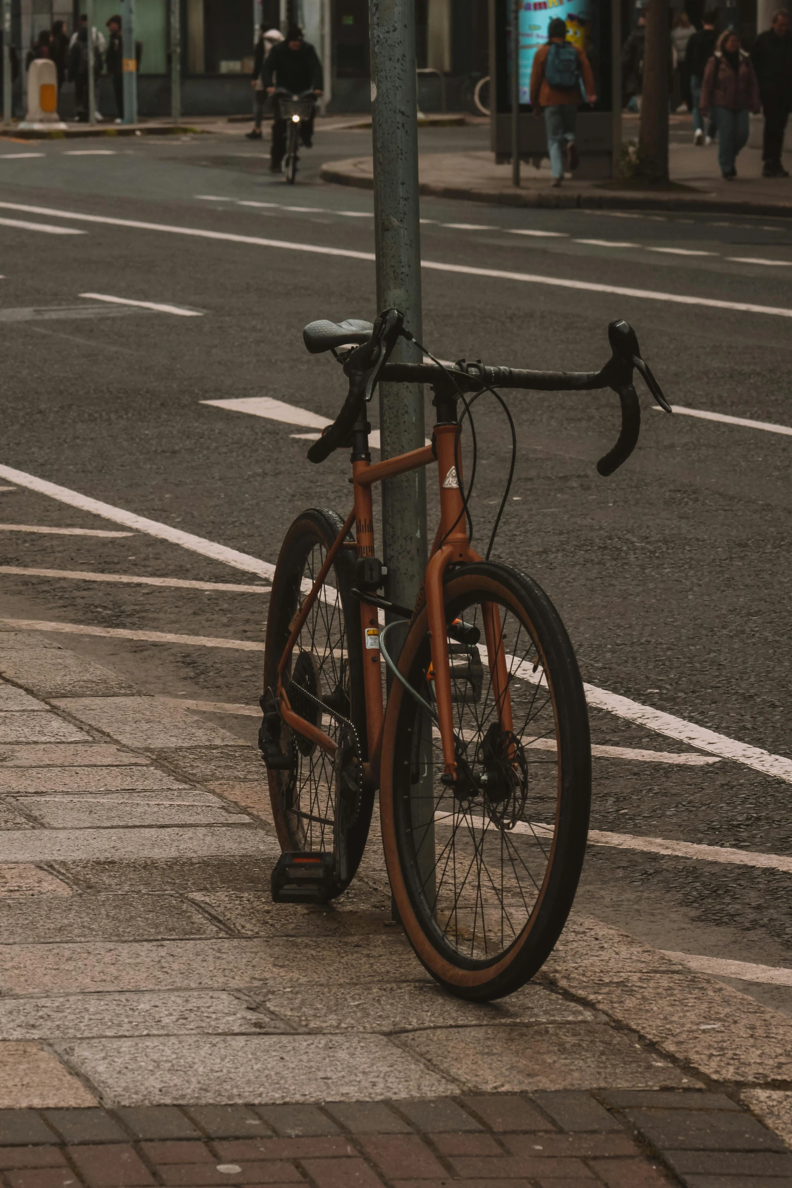 a bicycle is  to a pole on the sidewalk