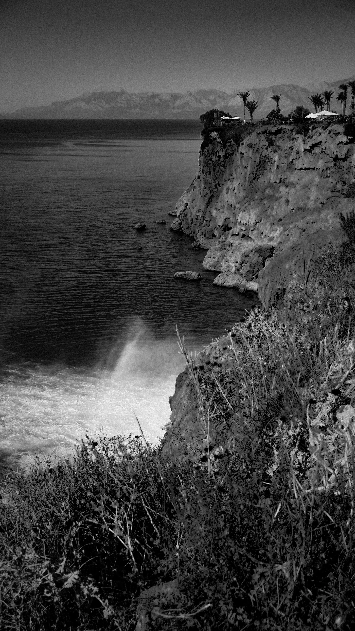 a person walking along the shore line next to some waves