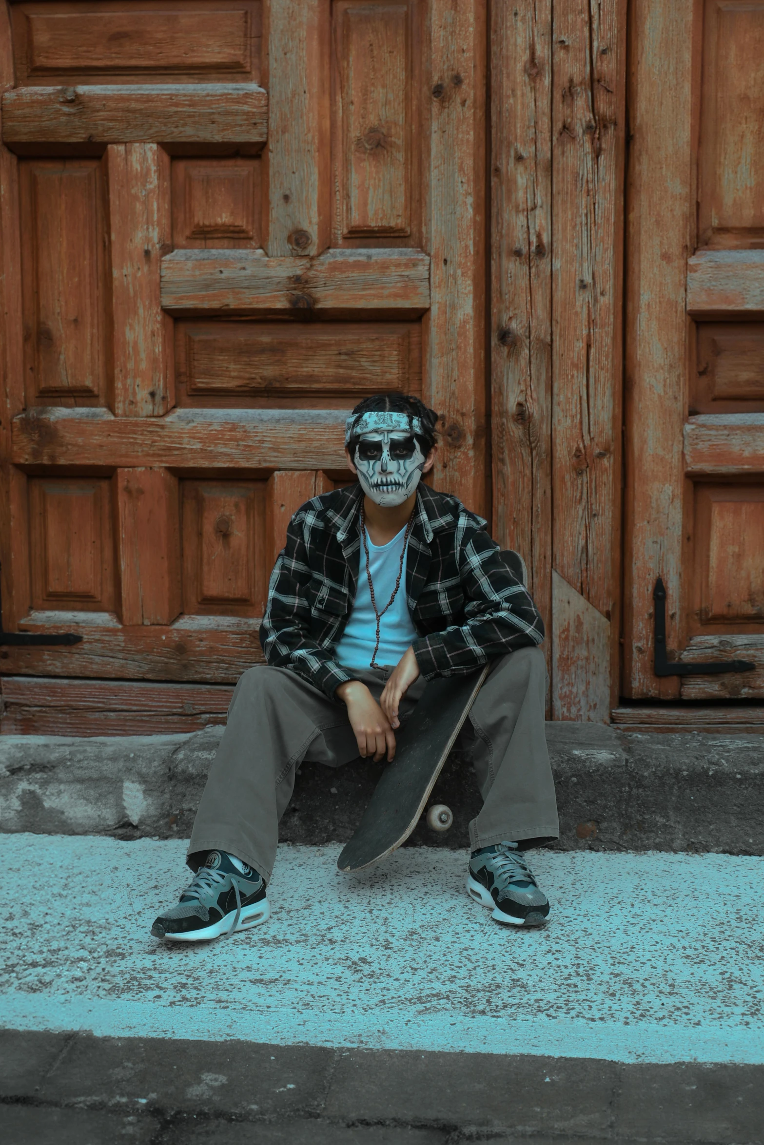 a man sitting with his skate board by a door