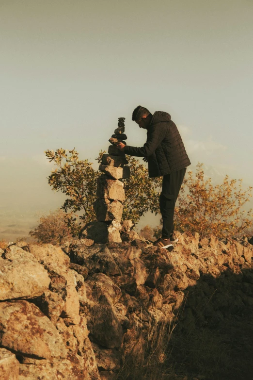 a person on a rock with a small camera