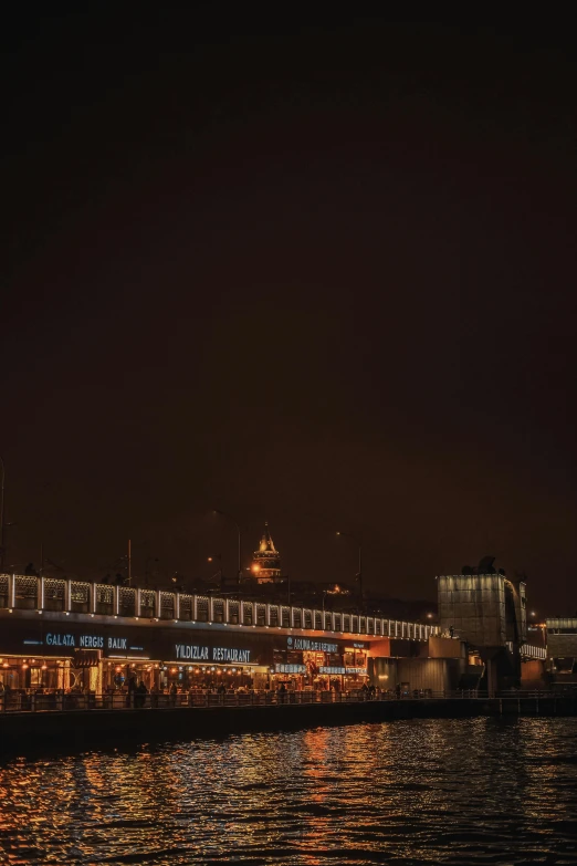 a large cruise ship near a bridge at night