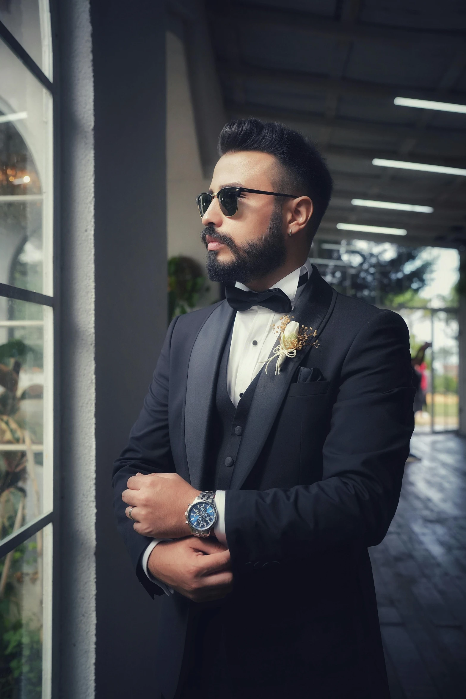 a man in a tuxedo stands outside of a store