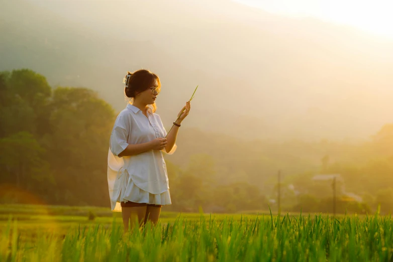 woman holding a stick while standing on a lush green field