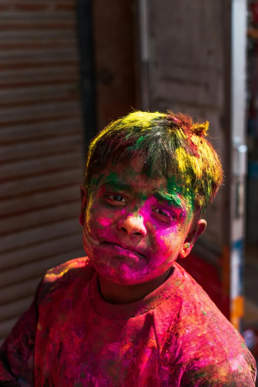 boy with colorful powder all over his face