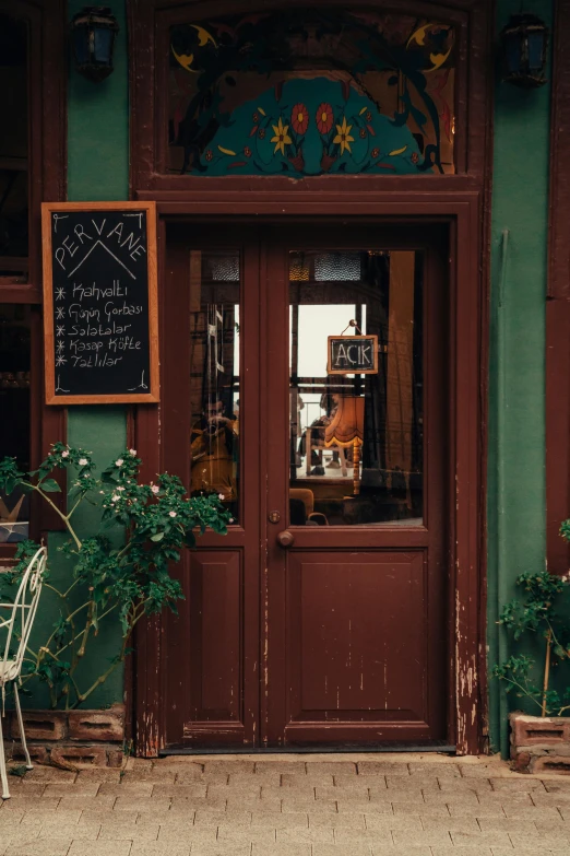 an outside view of a restaurant with chairs and table and sign