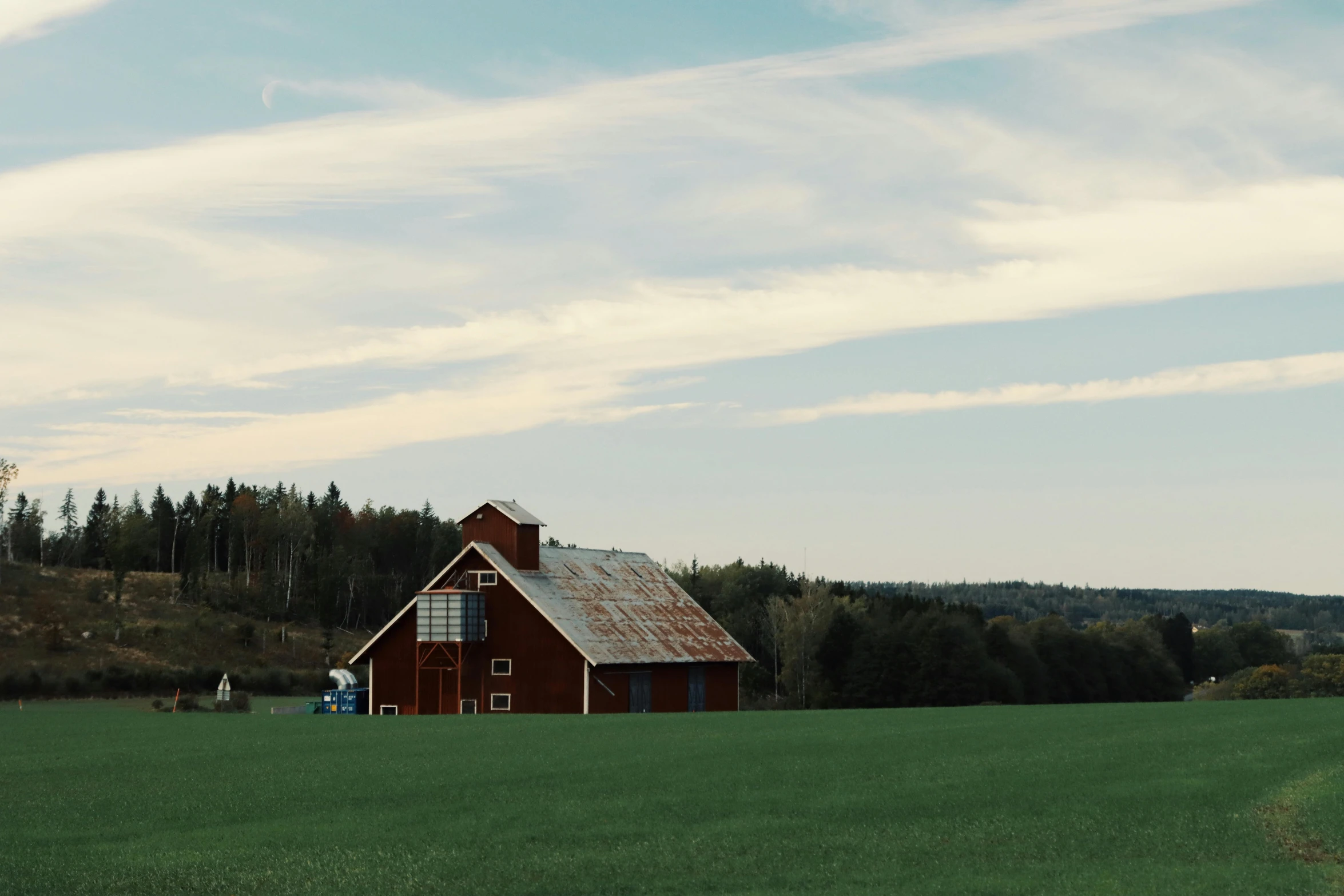 a picture of an old, small cabin near a wooded field