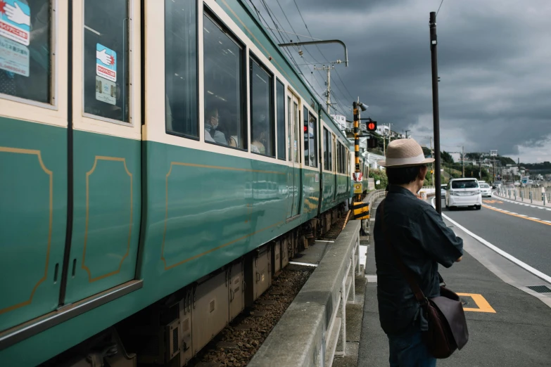 a person on the sidewalk looking out a train window