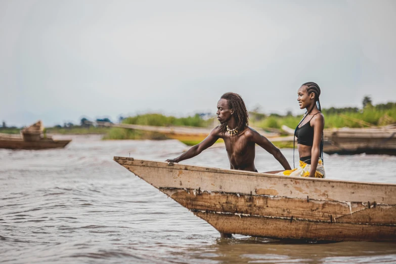 two african people on a small boat in the water