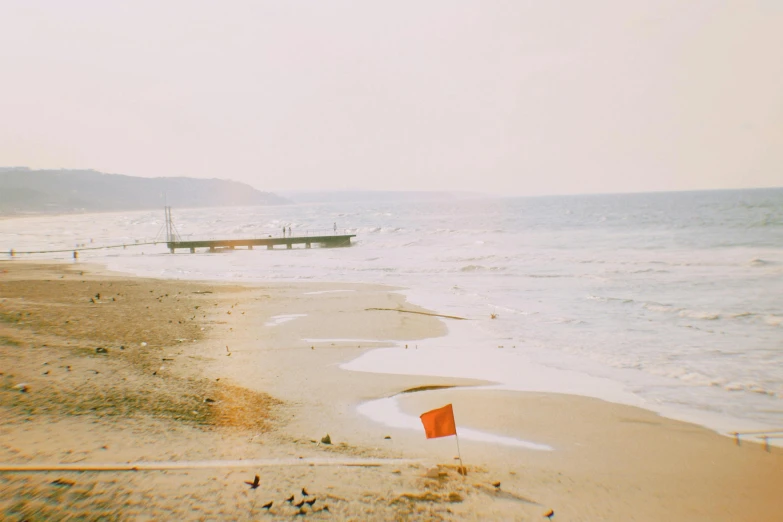 a small red flag on a sandy beach